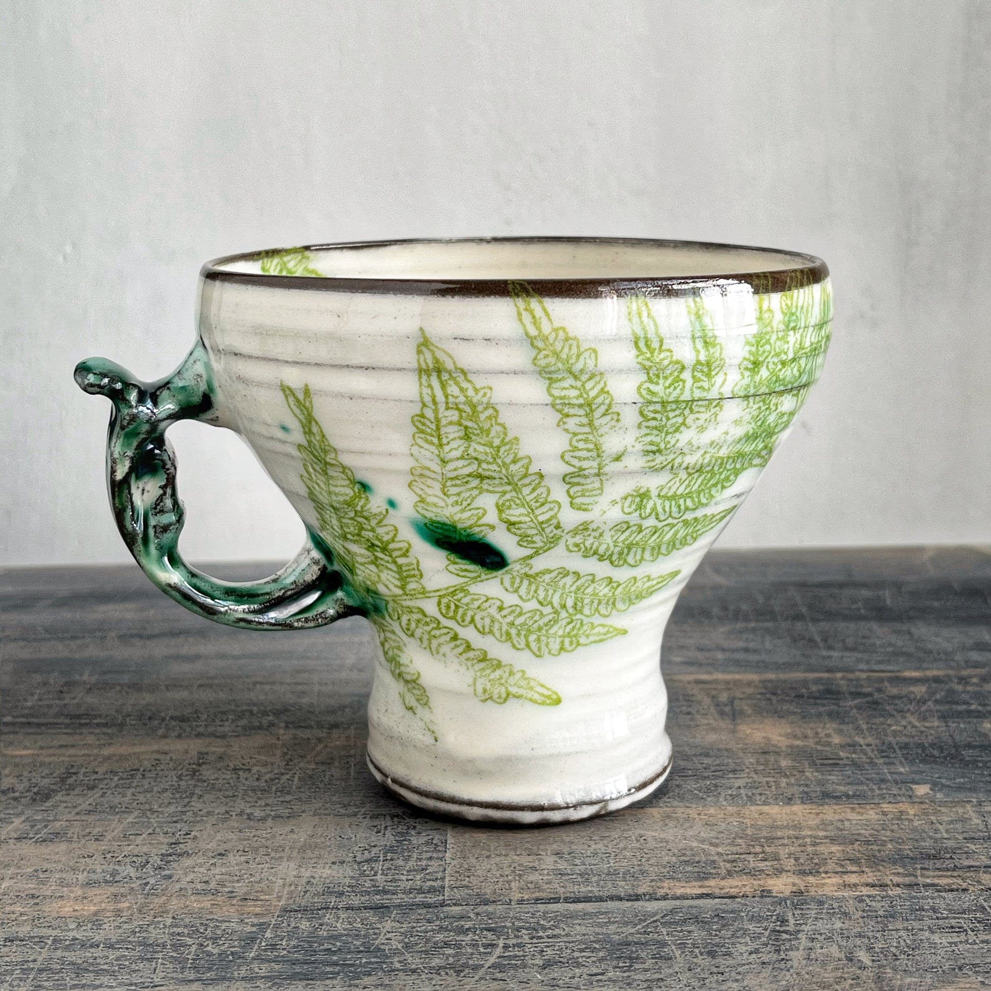 Wheel thrown ceramic mug, white with green fern motif 