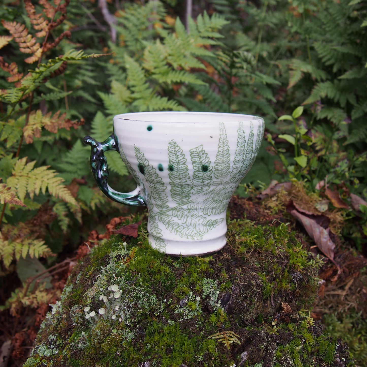 handmade ceramic mug with fern motif in the forest